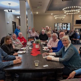 a group of people sitting at a table with plates