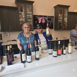 women with bottles of wine on a table