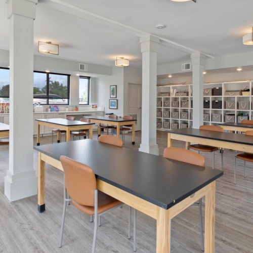 A perfect fit for the whole family Resident lounge at Solana Lakewood senior living apartments near Denver, CO, featuring tables with chairs.