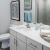 Model bathroom at our senior living apartments in Lakewood, CO, featuring wood grain floor paneling and white counters.