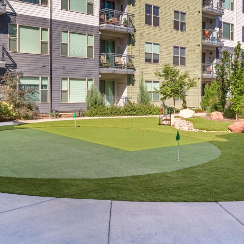 Cutting-edge amenities at your fingertips The putting green at Solana Lakewood senior living apartments near Denver, CO, featuring a view of the apartment exteriors.
