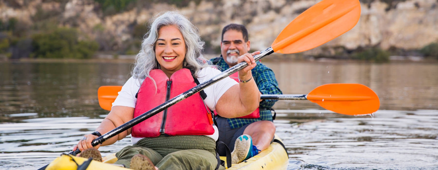 man and woman kayak on river